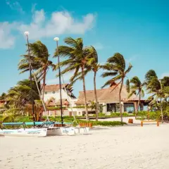 Plaża z palmami, katamaranami i budynkami hotelowymi. Idealne miejsce na egzotyczne wakacje.