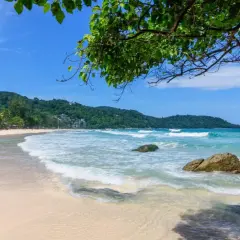 Piękna plaża Kata Beach z turkusową wodą, falami i palmami. Idealne miejsce na relaks.