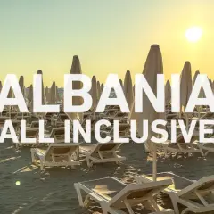 Słoneczna plaża w Albanii, rzędy leżaków i parasoli. Idealne miejsce na wczasy samolotem all inclusive.