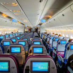 Wnętrze samolotu Ryanair z rzędami siedzeń i ekranami.