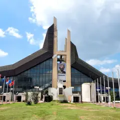 Prisztina, jego stolica, wita gości przed budynkiem z portretem Adema Jashari. Flagi powiewają na wietrze.