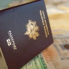 Otwarty paszport leży na mapie i stemplach wizowych. Czy na Gibraltar potrzebny jest paszport? Dokument podróży jest kluczem do zwiedzania świata.