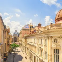 Ulica z zabytkowymi kamienicami i kopułą, idealna na tani city break.