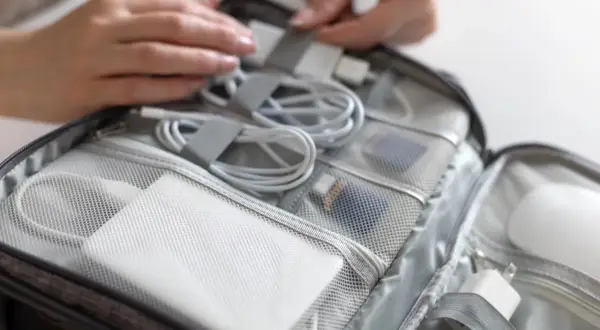W organizerze na bagaż podręczny znajduje się biały powerbank, kable i ładowarki.