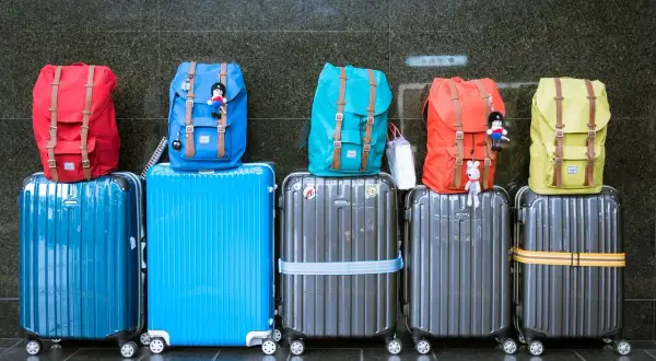 Kolorowe plecaki i walizki, gotowe na podróż z American Airlines. Idealny bagaż podręczny na wakacje.