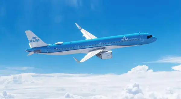 Niebieski Airbus A321 271NX linii KLM majestatycznie leci nad chmurami, symbolizując podróż i odkrycia.