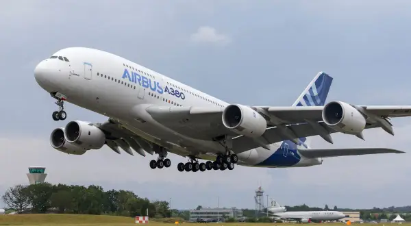 Ogromny Airbus A380 800 z podwoziem w górze startuje z lotniska.