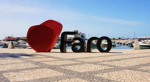 Serce i napis FARO na brukowanym placu przy marinie, tuż obok lotniska Algarve.