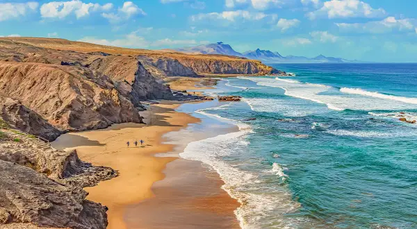 Plaża na Fuerteventurze, gdzie surferzy idą do wody. Tak, Wyspy Kanaryjskie należą do Unii Europejskiej.