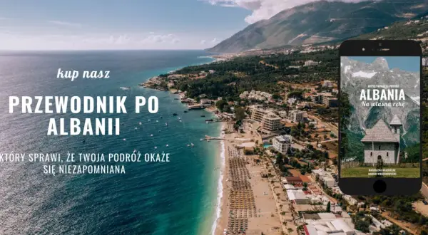 Przewodnik po Albanii, który sprawi, że Twoja podróż będzie niezapomniana. Widok na wybrzeże i góry, z telefonem prezentującym okładkę książki.