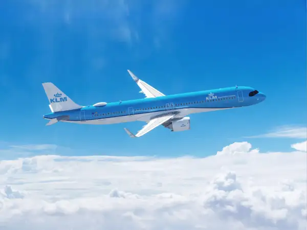 Niebieski Airbus A321 271NX linii KLM majestatycznie leci nad chmurami, symbolizując podróż i odkrycia.