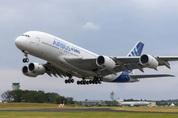Ogromny Airbus A380 800 z podwoziem w górze startuje z lotniska.