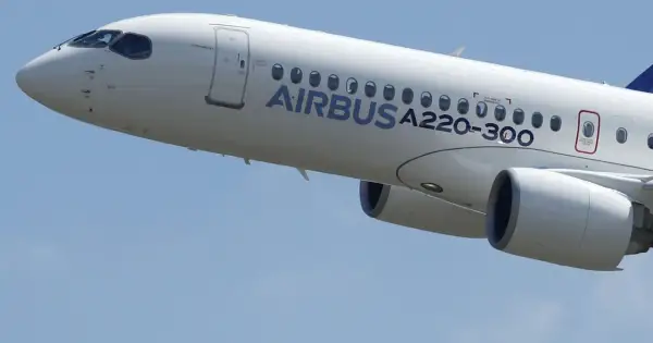 Biały samolot Airbus a220-300 wznosi się na błękitne niebo.
