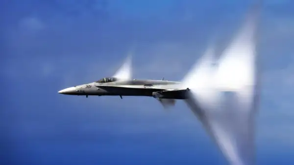 Myśliwiec F/A-18 Super Hornet przekracza barierę dźwięku, tworząc stożki kondensacji. Niesamowita prędkość samolotu w akcji.