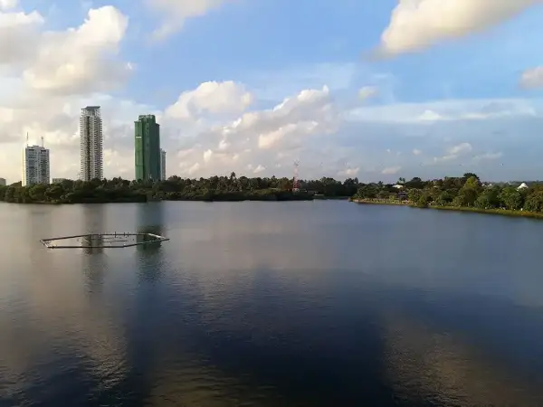 Widok na jezioro w Kolombo, stolicy Sri Lanki, z nowoczesnymi wieżowcami w tle i zielenią.